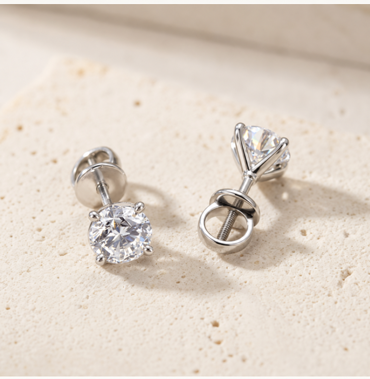 Three-quarter view of the RW diamond studs showing the four-claw flower setting and screw backs on cream concrete